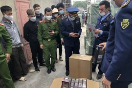 Lực lượng chức năng kiểm tra hàng hóa. (Ảnh: TTXVN phát)