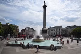 Người dân tránh nóng bên đài phun nước tại Quảng trường Trafalgar ở thủ đô London, Anh. (Ảnh: AFP/TTXVN)