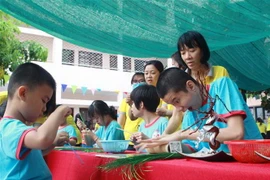 Hướng dẫn các em khuyết tật tại Trung tâm Phục hồi chức năng và Trợ giúp trẻ em khuyết tật Thành phố Hồ Chí Minh. (Nguồn: TTXVN)