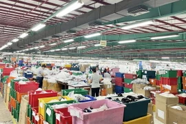 Công nhân Công ty TNHH Triumph International Việt Nam quay trở lại làm việc. (Ảnh: TTXVN phát)