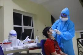 Lấy mẫu xét nghiệm COVID-19 cho trẻ em. (Nguồn: TTXVN)