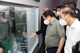 Thủ tướng Phạm Minh Chính xem quy trình chế biến thịt gia cầm xuất khẩu của Công ty trách nhiệm hữu hạn CPV Food. (Ảnh: Dương Giang/TTXVN)