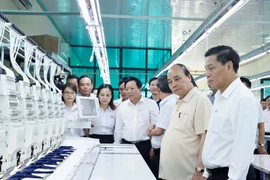 Chủ tịch nước Nguyễn Xuân Phúc thăm các phân xưởng sản xuất tại Công ty trách nhiệm hữu hạn thương mại Sao Mai. (Ảnh: Thống Nhất/TTXVN)