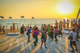 Du khách đón hoàng hôn tại bãi biển Sunset Sanato, Bãi Trường, thành phố Phú Quốc, tỉnh Kiên Giang. (Ảnh: Hồng Đạt/TTXVN)