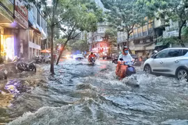 Người dân di chuyển giữa 'biển nước' trên đường Phạm Ngũ Lão (quận 1). (Ảnh: Hồng Giang/TTXVN)