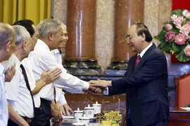 Chủ tịch nước Nguyễn Xuân Phúc với các cán bộ từng phục vụ và bảo vệ Bác Hồ. (Ảnh: Thống Nhất/TTXVN)