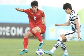 Một pha tranh chấp bóng của Khuất Văn Khang (áo đỏ). (Ảnh: TTXVN phát)