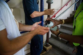 Người dân khử khuẩn tay tại điểm tiêm vaccine phòng bệnh đậu mùa khỉ ở New York, Mỹ. (Ảnh: THX/TTXVN)
