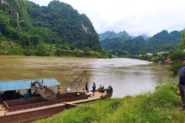 Lực lượng tìm kiếm cứu nạn tìm kiếm các nạn nhân mất tích trên dòng sông Gâm. (Ảnh: TTXVN phát)