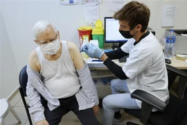 Tiêm mũi 4 vaccine phòng COVID-19 cho người dân tại thành phố Tel Aviv, Israel. (Ảnh: AFP/TTXVN)