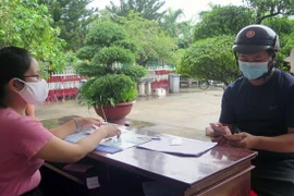 Chi trả tiền hỗ trợ người dân bị ảnh hưởng bởi dịch COVID-19. (Nguồn: TTXVN)