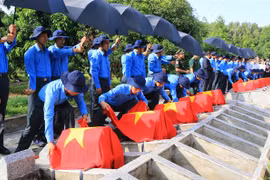 Đội K91 thực hiện nghi thức an táng hài cốt các liệt sỹ. (Ảnh: Nhựt An/TTXVN)
