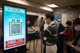 Người dân quét mã kiểm tra y tế trước khi vào tòa nhà tại Hong Kong, Trung Quốc, ngày 9/12/2021. (Ảnh: AFP/TTXVN)