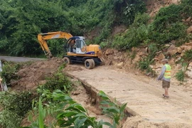 Khắc phục sạt lở do bão trên tuyến ĐT 611. (Ảnh: Hữu Trung/TTXVN)