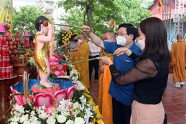 Thực hiện nghi lễ tắm Phật. (Ảnh: Quang Cường/TTXVN)