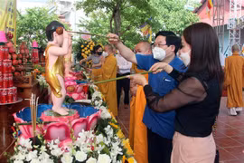 Thực hiện nghi lễ tắm Phật. (Ảnh: Quang Cường/TTXVN)