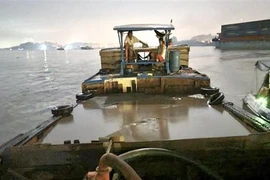 Lực lượng cảnh sát đường thủy tỉnh Đồng Nai phát hiện, kiểm tra phương tiện vận chuyển cát không rõ nguồn gốc. (Ảnh: TTXVN phát)