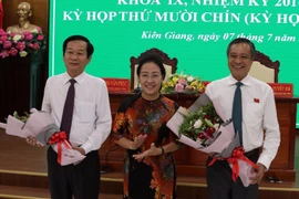 Tặng hoa chúc mừng tân Chủ tịch Đỗ Thanh Bình (trái) và nguyên Chủ tịch UBND tỉnh Phạm Vũ Hồng. (Ảnh: Lê Sen/TTXVN)
