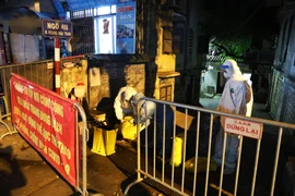 Lực lượng y tế phun khử khuẩn tại ngõ 466 Hoàng Hoa Thám.(Ảnh: Lâm Khánh/TTXVN)