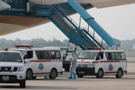 Sau khi xuống máy bay, các công dân được ôtô chuyên dùng đưa về cơ sở cách ly y tế. (Ảnh: Thành Đạt/TTXVN)