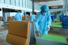 Vệ sinh, khử trùng khu vực nhà ga đến tại Sân bay quốc tế Cam Ranh sau mỗi đợt đón khách quốc tế. (Ảnh: Nguyễn Dũng/TTXVN)