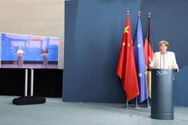 Thủ tướng Đức Angela Merkel họp báo trực tuyến cùng Chủ tịch Ủy ban EU Ursula von der Leyen (màn hình vô tuyến, bên trái) và Chủ tịch Hội đồng châu Âu Charles Michel (màn hình vô tuyến, bên phải) sau Hội nghị thượng đỉnh EU-Trung Quốc. (Ảnh: Mạnh Hùng/TTX