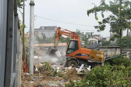 Cưỡng chế giải phóng mặt bằng tại thôn Đoài và thôn Đông, xã Kim Nỗ (Đông Anh). (Ảnh: Mạnh Khánh/TTXVN)