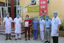 Trao giấy ra viện cho bệnh nhân số 620. (Ảnh: Thanh Tuấn/TTXVN)