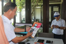 Cài đặt App du lịch Quy Nhơn Bình Định trên điện thoại di động. (Ảnh: Phạm Kha/TTXVN)