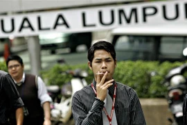 Người dân hút thuốc lá trên đường phố tại Kuala Lumpur, Malaysia. (Ảnh: AFP/ TTXVN)