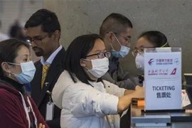 Hành khách đeo khẩu trang đề phòng lây nhiễm COVID-19 tại sân bay quốc tế Los Angeles, bang California, Mỹ. (Ảnh: AFP/TTXVN)
