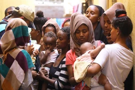 Người di cư bất hợp pháp tập trung tại một trại tạm thời ở Tripoli, Libya. (Ảnh: AFP/TTXVN)