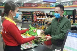 Người dân chủ động phòng, chống dịch COVID-19 bằng cách đeo khẩu trang khi đi chợ, siêu thị. (Ảnh: TTXVN)