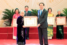 Chủ tịch nước Trần Đại Quang trao Giải thưởng Hồ Chí Minh cho đại diện gia đình Liệt sỹ, Nhà báo Lương Nghĩa Dũng, nguyên phóng viên Thông tấn xã Việt Nam trong thời kỳ kháng chiến chống Mỹ cứu nước. (Ảnh: Nhan Sáng/TTXVN)