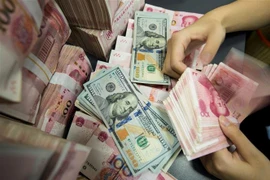 Kiểm đồng 100 nhân dân tệ tại ngân hàng ở Bắc Kinh, Trung Quốc. (Ảnh: AFP/TTXVN)