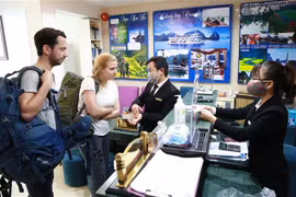 Khách du lịch được phát khẩu trang và được hướng dẫn vệ sinh bằng dung dịch khử khuẩn. (Ảnh: Doãn Tấn/TTXVN)