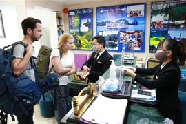 Khách du lịch được phát khẩu trang và được hướng dẫn vệ sinh bằng dung dịch khử khuẩn. (Ảnh: Doãn Tấn/TTXVN)