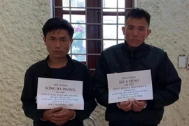 Hai đối tượng cùng tang vật tại cơ quan Công an. (Ảnh: TTXVN phát)