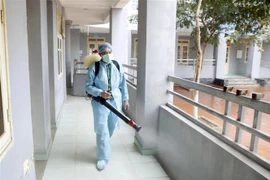Nhân viên y tế phun thuốc tiêu độc khử trùng tại trường THPT Chuyên Hưng Yên, thành phố Hưng Yên. (Ảnh: Phạm Kiên/TTXVN)