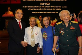 Bí thư Thành ủy Thành phố Hồ Chí Minh Nguyễn Thiện Nhân cùng các lão thành cách mạng nhận huy hiệu Đảng. (Ảnh: Thanh Vũ/TTXVN)