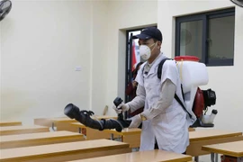 Phun thuốc khử trùng tại trường Tiểu học Hoàng Diệu, quận Ba Đình để phòng chống dịch bệnh viêm đường hô hấp cấp do chủng mới của virus corona. (Ảnh: Thanh Tùng/TTXVN)