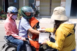 Phát khẩu trang miễn phí cho người dân đeo phòng dịch bệnh viêm đường hô hấp cấp do nCoV. (Ảnh: Công Thử/TTXVN)