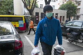 Một tài xế giao đồ ăn tới bệnh viện ở Vũ Hán, tỉnh Hồ Bắc, Trung Quốc. (Ảnh: THX/TTXVN)