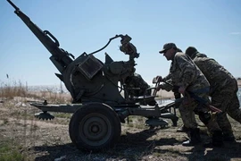 Các binh sỹ chính phủ Ukraine triển khai vũ khí tại bãi biển Azov, miền Đông Ukraine. (Ảnh: AP)