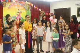 Các cháu tham gia trò chơi giải câu đố về Trung thu. (Ảnh: Hoàng Nhương/Vietnam+)