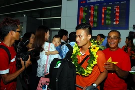 Các cầu thủ tuyển futsal Việt Nam trong vòng tay người hâm mộ. (Ảnh: Mạnh Linh/TTXVN)
