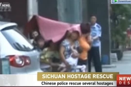 Hai kẻ bắt cóc chùm chăn lên đầu con tin. (Nguồn: CCTV)