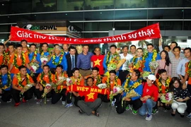 Người hâm mộ chào đón và tặng hoa cho đội tuyển futsal Việt Nam. (Ảnh: Mạnh Linh/TTXVN)