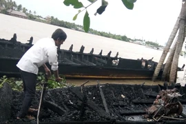 Tàu bị cháy rụi sau vụ hỏa hoạn. (Ảnh: Trần Thị Thu Hiền/TTXVN)