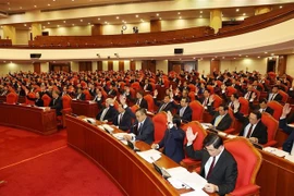 Các đồng chí lãnh đạo Đảng, Nhà nước và các đại biểu biểu quyết thông qua chương trình hội nghị trong ngày khai mạc. (Ảnh: Trí Dũng/TTXVN)